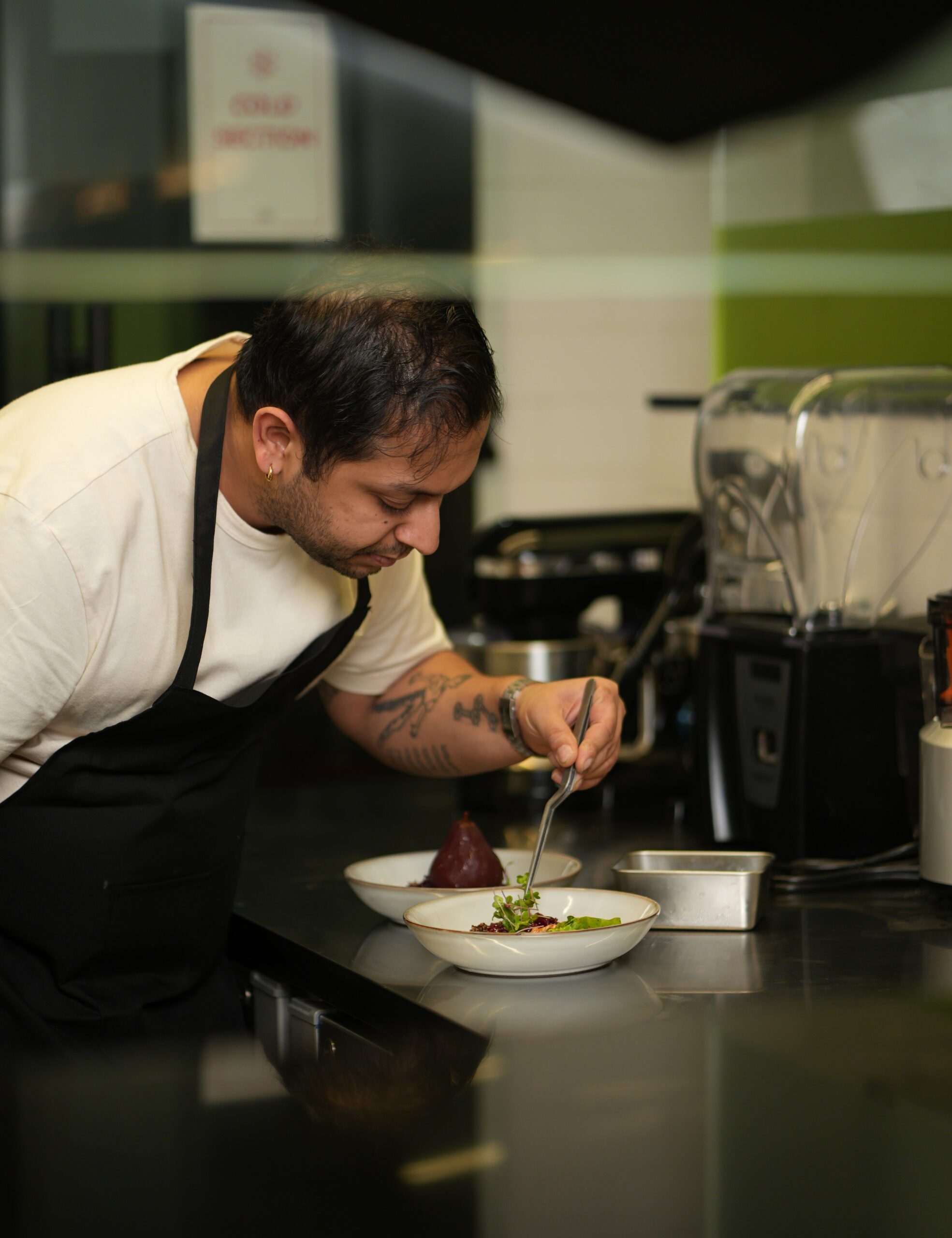 Chef Vedant Newatia plating a dish in the Atelier V kitchen